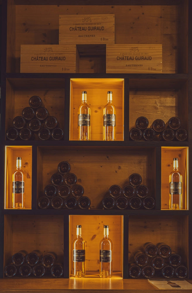 Weinflaschen und Weinkisten im Regal.